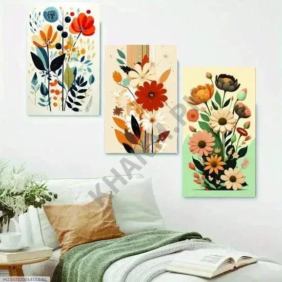 Three floral art prints on a wall above a sofa with a plant and coffee table.