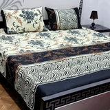 Decorative bedspread with floral and zebra pattern on a bed in a room.