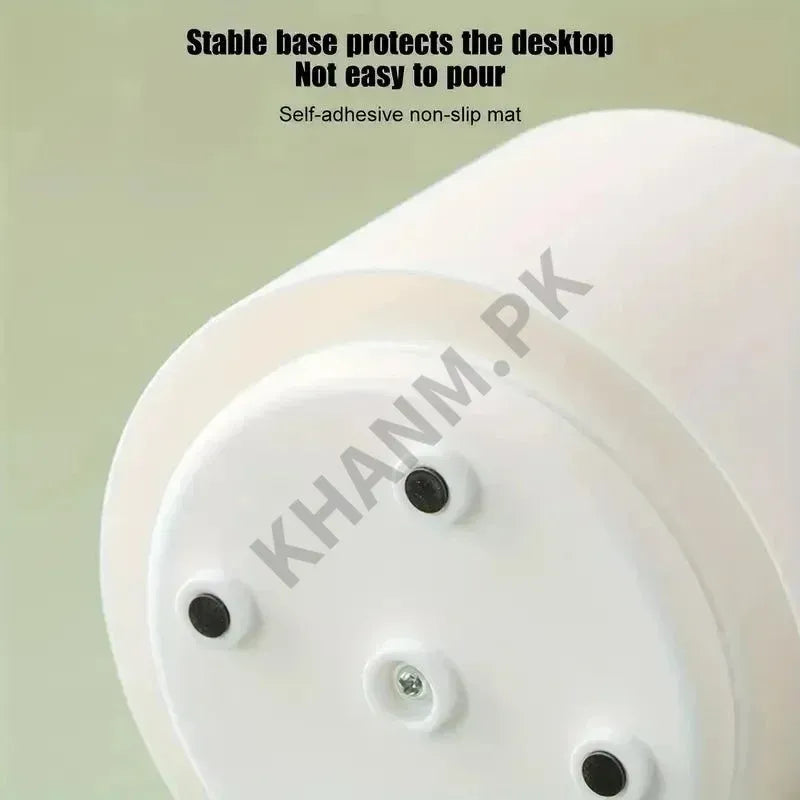 White circular object with adhesive pads on a light green background